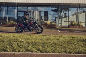 BMW R 12 2025 – Seitenansicht mit Fahrer in Bewegung, Aventurinrot