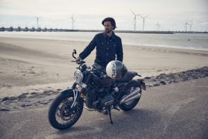 BMW R 12 nineT 2025 – Seitenansicht mit Fahrer am Strand, Schwarz