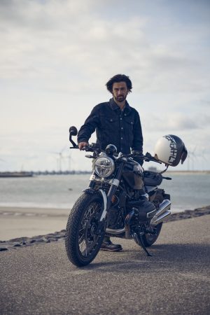 BMW R 12 nineT 2025 – Frontansicht mit Fahrer an der Küste, Schwarz