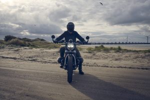 BMW R 12 nineT 2025 – Frontansicht mit Fahrer am Strand, Schwarz