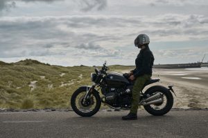 BMW R 12 nineT 2025 – Seitenansicht mit Fahrer am Strand, Schwarz