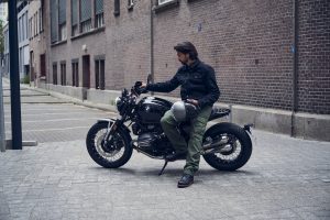 BMW R 12 nineT 2025 – Seitenansicht mit Fahrer in Altstadtgasse, Schwarz