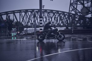 BMW R 12 nineT 2025 – Seitenansicht mit Fahrer bei Regen, Schwarz
