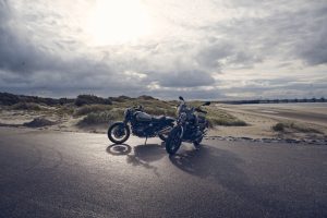 BMW R 12 und R 12 nineT 2025 – Heckansicht beider Modelle am Strand, Schwarz und Silber