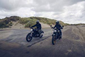 BMW R 12 und R 12 nineT 2025 – zwei Modelle in Fahrt am Strand, Schwarz und Avus-Silber