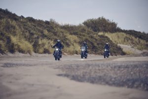 BMW R 12 und R 12 nineT 2025 – drei Fahrer mit beiden Modellen am Strand, Schwarz