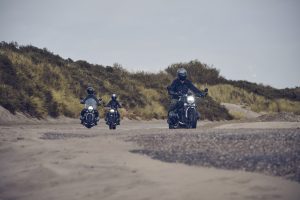 BMW R 12 und R 12 nineT 2025 – drei Fahrer mit beiden Modellen in Fahrt, Schwarz und Avus-Silber