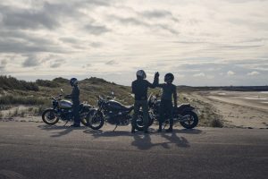 BMW R 12 und R 12 nineT 2025 – drei Fahrer mit beiden Modellen am Strand, Schwarz