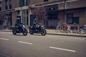 BMW R 12 und R 12 nineT 2025 – zwei Fahrer mit beiden Modellen in der Stadt, Schwarz und Avus-Silber
