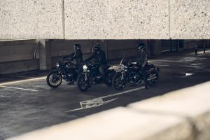 BMW R 12 und R 12 nineT 2025 – drei Maschinen mit Fahrern im Parkhaus, Schwarz