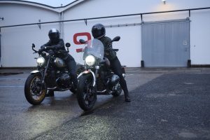 BMW R 12 und R 12 nineT 2025 – zwei Maschinen mit Fahrern vor Halle