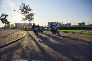 BMW R 12 und R 12 nineT 2025 – zwei Maschinen mit Fahrern im Gegenlicht, Schwarz