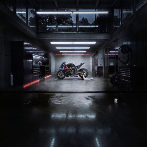 BMW S 1000 RR 2027 Edition M Sport in einer dunklen Design-Garage, Frontalansicht aus der Distanz