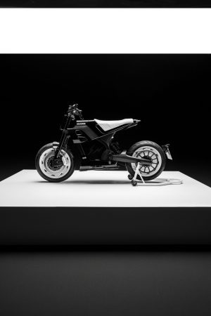 BRABUS Urban-E Fragment Edition 2026 – Seitenansicht von links mit Monocoque-Tank-Sitzverkleidung, Carbon-Seitenteilen und Montageständer auf weißem Podest