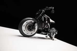 BRABUS Urban-E Fragment Edition 2026 – Dreiviertelansicht von vorn rechts mit weißen Carbon-Radabdeckungen auf weißem Podest