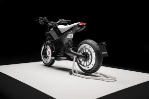BRABUS Urban-E Fragment Edition 2026 – Dreiviertelansicht von hinten rechts mit weißen Radabdeckungen und Montageständer