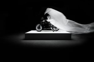 BRABUS Urban-E Fragment Edition 2026 – Enthüllung auf dem Podest – die weiße Plane wird vom Motorrad gezogen