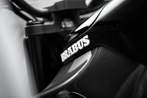 BRABUS Urban-E Fragment Edition 2026 – BRABUS-Schriftzug auf der Carbon-Tankverkleidung zwischen weißer Folie
