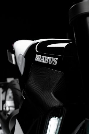 BRABUS Urban-E Fragment Edition 2026 – BRABUS-Logo auf der Frontverkleidung mit Tagfahrleuchte im Hochformat