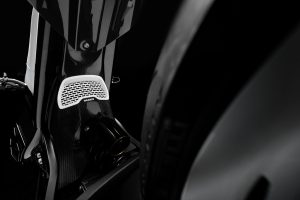 BRABUS Urban-E Fragment Edition 2026 – Weißes Lüftungsgitter mit BRABUS-Logo auf der Carbon-Rahmenverkleidung über dem Federbein