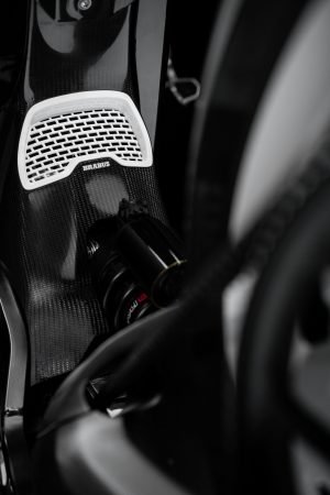 BRABUS Urban-E Fragment Edition 2026 – Weißes Lüftungsgitter mit BRABUS-Logo und Carbon-Abdeckung im Hochformat