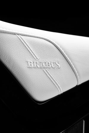 BRABUS Urban-E Fragment Edition 2026 – Weißer Ledersitz mit geprägtem BRABUS-Schriftzug und Ziernaht im Hochformat