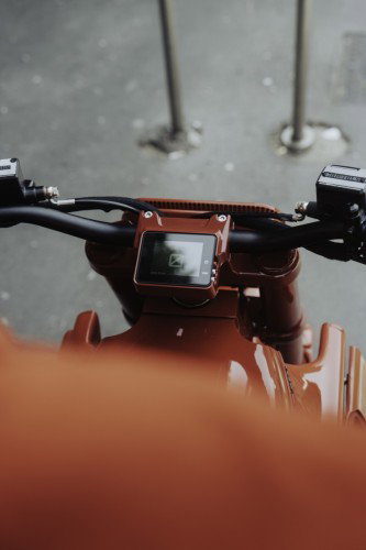 BRABUS URBAN E First Edition Fusion Red 2026 – Stehender Fahrer mit passendem Fusion-Red-Helm neben dem Motorrad