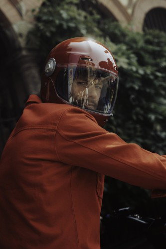 BRABUS URBAN E First Edition Fusion Red 2026 – Nahaufnahme des Fahrers mit lackiertem Integralhelm in Fusion Red im Mailänder Innenhof