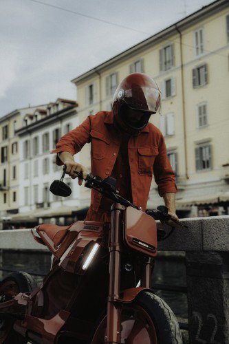 BRABUS URBAN E First Edition Fusion Red 2026 – Dynamische Fahraufnahme vor Mailänder Arkadenarchitektur