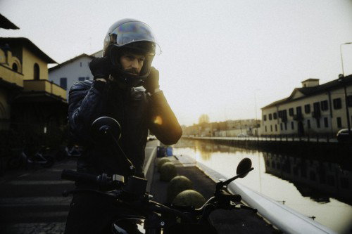 DAB 1a BRABUS 2026 – Fahrer steigt vom Motorrad ab, historische Mailänder Fassade im Hintergrund