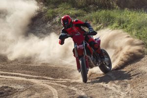 Ducati Desmo450 SM 2027 – Frontansicht beim Driften durch eine sandige Offroad-Kurve