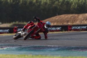 Ducati Desmo450 SM 2027 – Tiefe Schräglage mit Knie am Boden vor Werbebanden