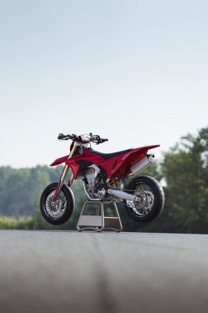 Ducati Desmo450 SM 2027 – Linke Seite schräg von vorn auf Montageständer vor Himmel, Hochformat