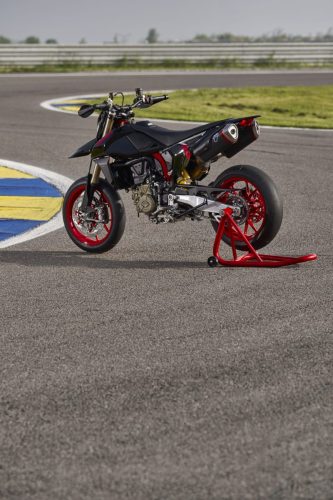 Ducati Hypermotard 698 Mono Nera 2027 – Dreiviertel-Heckansicht auf rotem Montageständer mit Termignoni-Auspuff und Aluminium-Zweiarmschwinge auf Rennstrecke