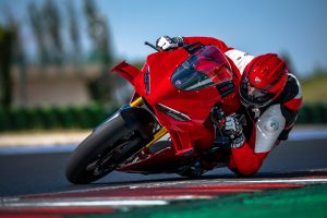Ducati Panigale V4 S 2027 – in Ducati-Rot in tiefer Schräglage mit Knie am Boden auf der Rennstrecke