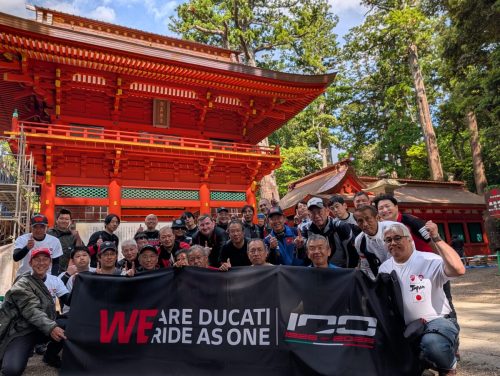 Ducati #WeRideAsOne 2026 – Gruppenfoto vor rotem japanischem Tempel mit WeRideAsOne-Banner und Ducati100-Logo