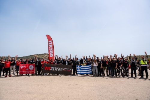 Ducati #WeRideAsOne 2026 – Ducati Official Club Hellas Gruppenfoto mit griechischer Flagge und Ducati-Beachflag an der Küste