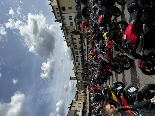 Ducati #WeRideAsOne 2026 – Zahlreiche geparkte Ducati-Motorräder vor historischem Gebäude bei Gruppenausfahrt