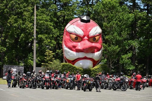 Ducati #WeRideAsOne 2026 – Ducati-Motorräder vor großer Tengu-Maske in japanischem Park bei Sonnenschein