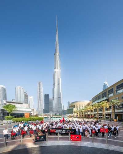 Ducati #WeRideAsOne 2026 – Gruppenfoto vor dem Burj Khalifa in Dubai mit WeRideAsOne-Banner und Ducati100-Logo