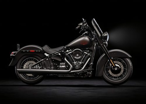 Harley-Davidson Deadwood – mattschwarzer Cruiser in Seitenansicht von links im dunklen Studio, mit Speichenrädern, V2-Motor und schlankem Solositz