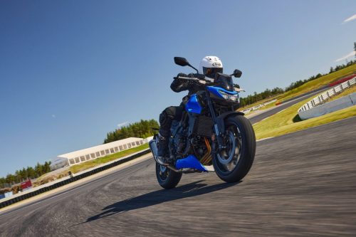 Honda CB750 Hornet 2027 in Glint Wave Blue auf der Rennstrecke, Frontansicht mit LED-Doppelscheinwerfer und aufgerichtetem Fahrwerk