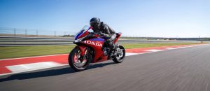 Honda CBR500R FOUR 2027 in Ignition Red Tricolour auf der Geraden der Rennstrecke, Panoramaformat
