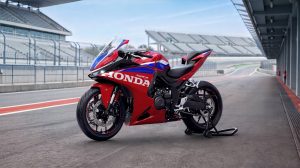 Honda CBR500R FOUR 2027 in Ignition Red Tricolour auf Montageständer in der Boxengasse vor der Tribüne