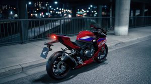 Honda CBR500R FOUR 2027 in Ignition Red Tricolour nachts in der Stadt, Heckansicht mit LED-Rücklicht