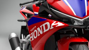 Honda CBR500R FOUR 2027 in Ignition Red Tricolour – Seitenverkleidung mit Honda-Schriftzug und Schalldämpfer im Detail