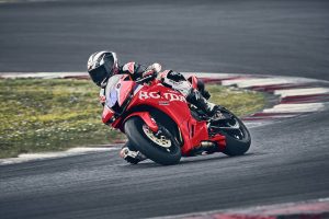 Honda CBR600RR 2027 in Ignition Red HRC TriColour in einer Rechtskurve über die rot-weißen Curbs
