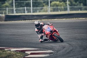 Honda CBR600RR 2027 in Ignition Red HRC TriColour in einer engen Rechtskurve auf der Rennstrecke