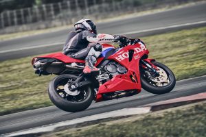 Honda CBR600RR 2027 in Ignition Red HRC TriColour beim Herausbeschleunigen aus einer Linkskurve