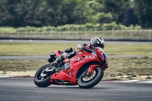 Honda CBR600RR 2027 in Ignition Red HRC TriColour beim Einlenken in eine Linkskurve
